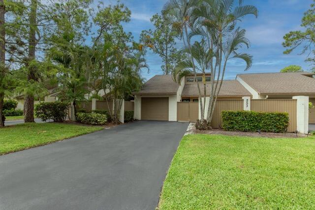 front view of a house with a yard and an trees