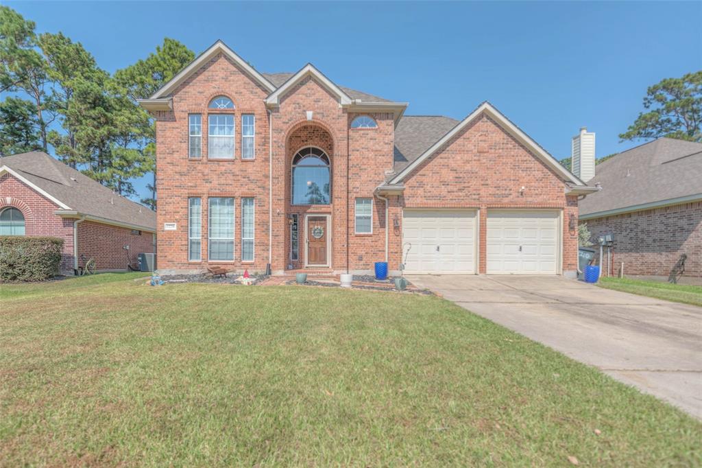 front view of a house with a yard and garage