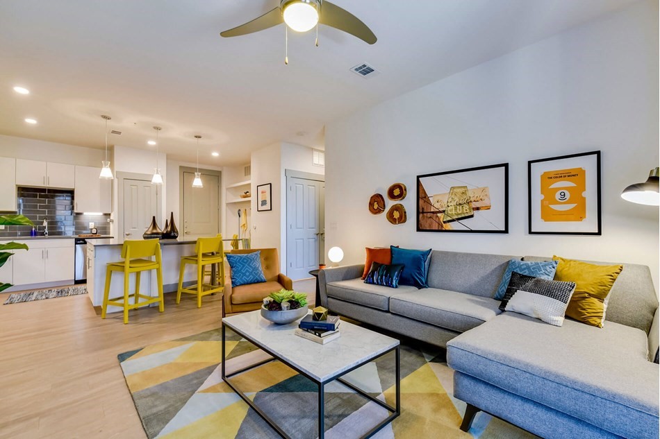 a living room with furniture kitchen view and a chandelier