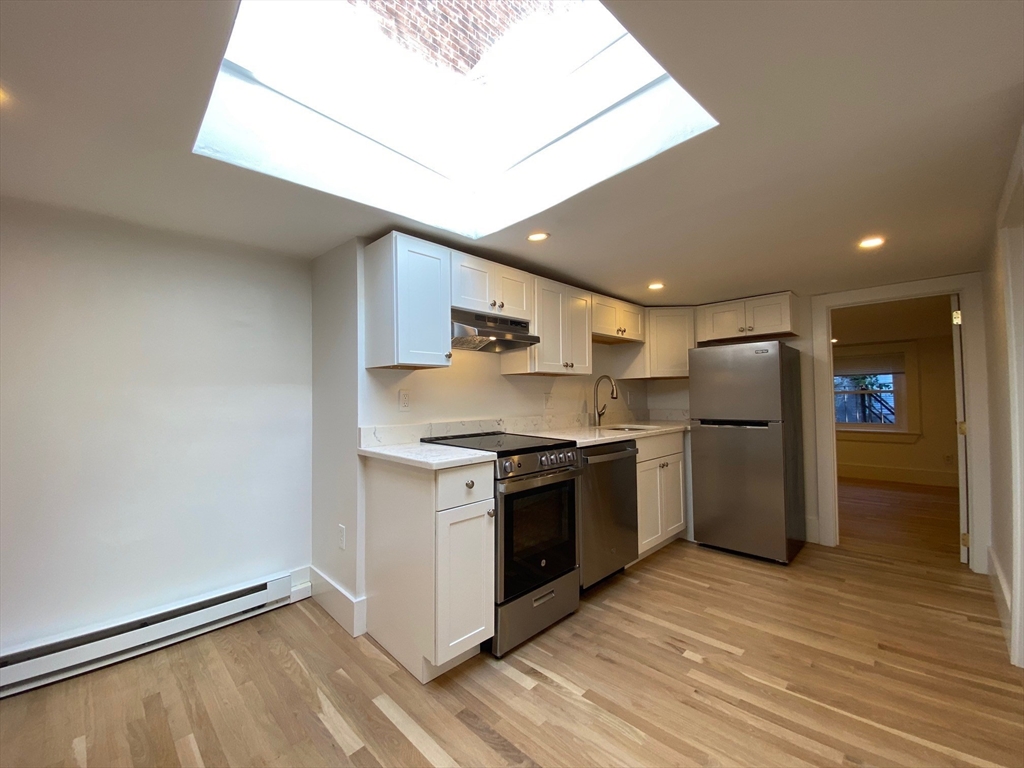 a kitchen with stainless steel appliances granite countertop a refrigerator and a stove top oven