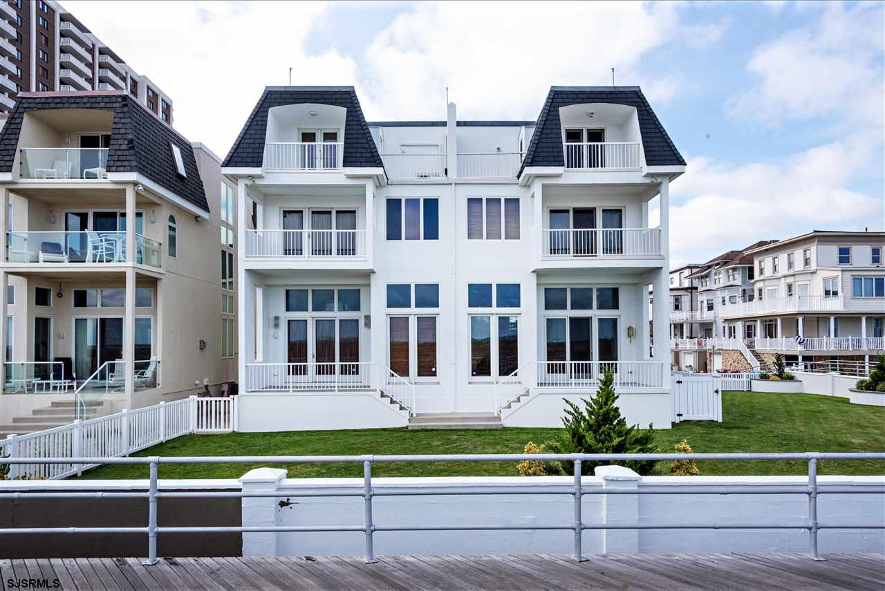 a front view of residential houses with yard and green space