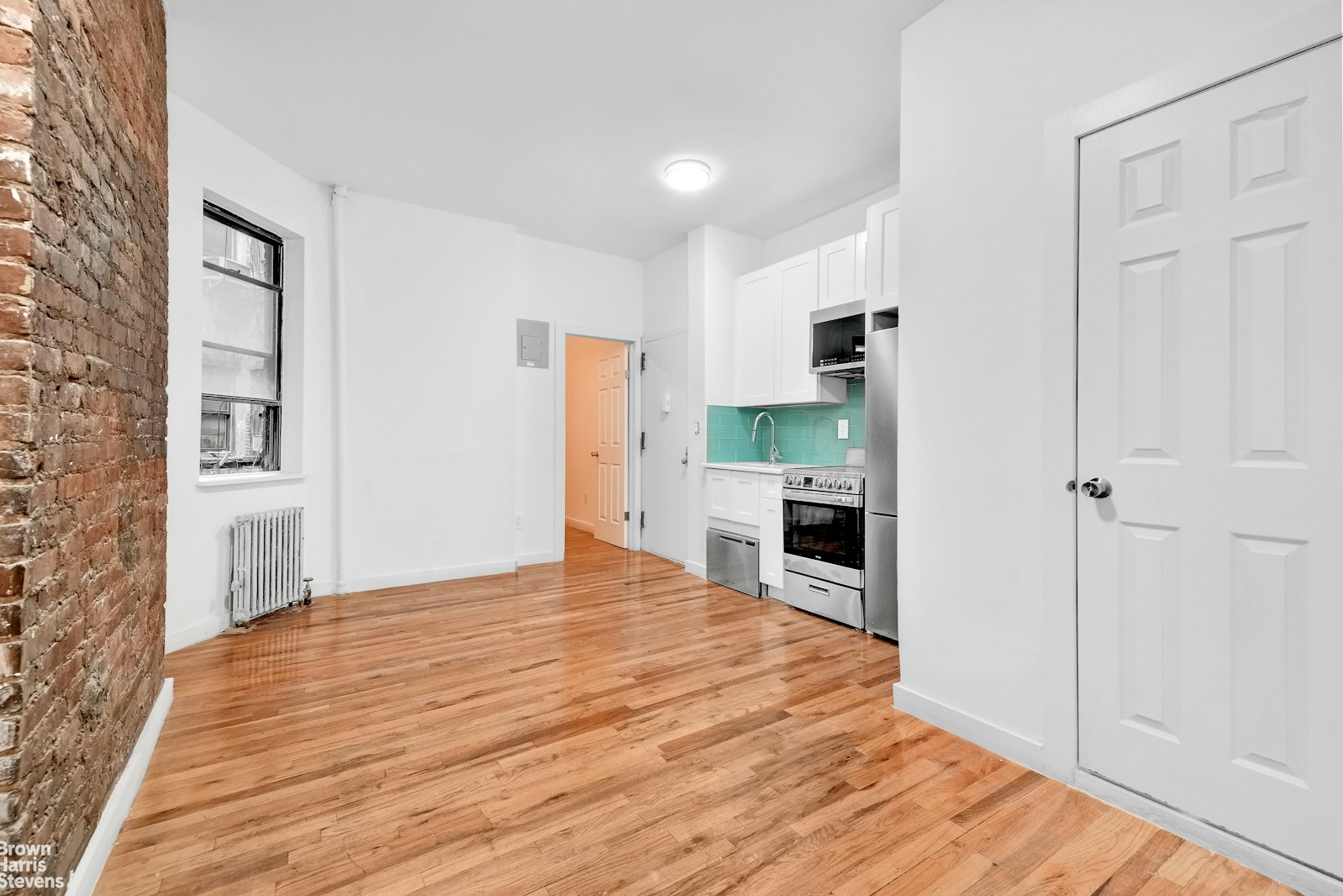 a view of a kitchen with wooden floor and a fireplace