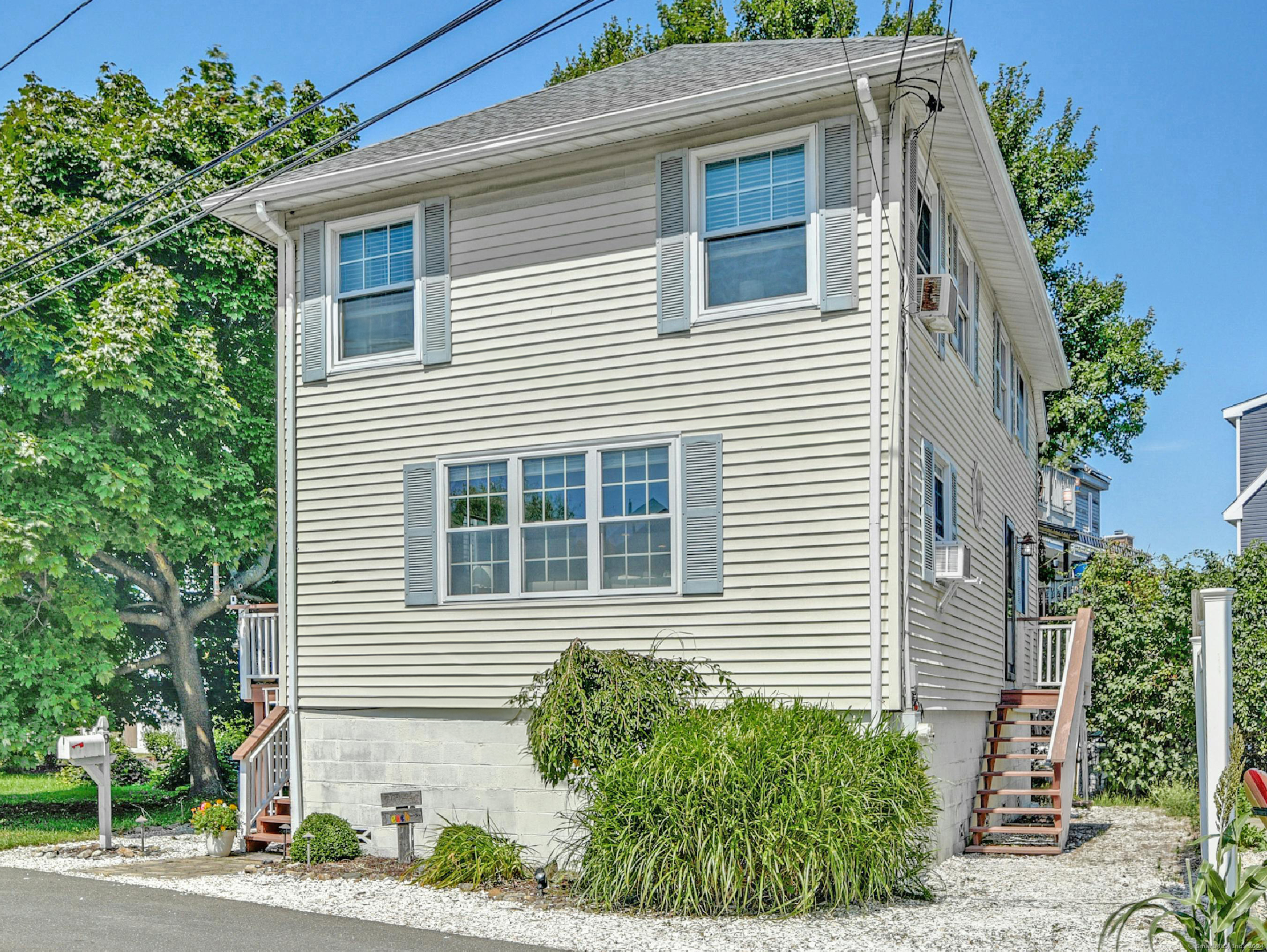 a view of a house with a yard and potted plants