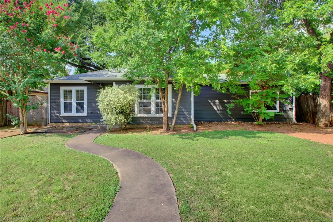 a view of a house with backyard and a garden