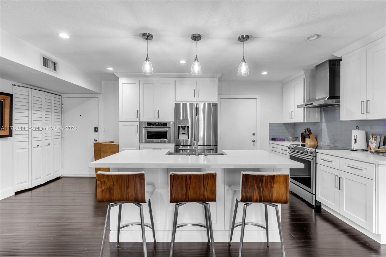 a kitchen with kitchen island a stove a table and chairs in it