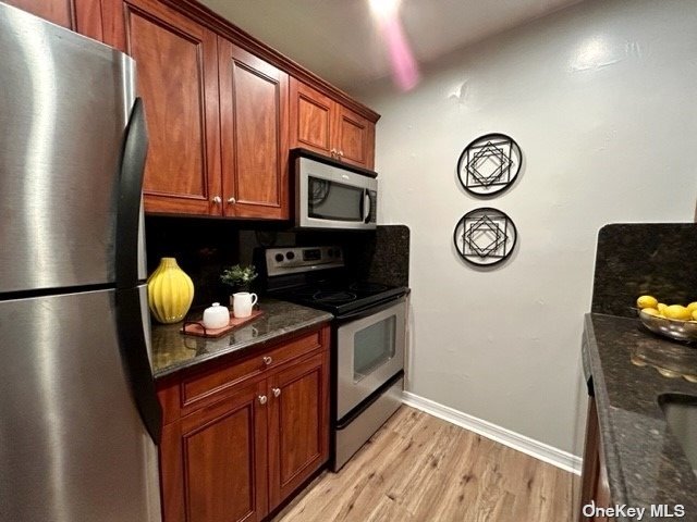 a kitchen with stainless steel appliances granite countertop a refrigerator a stove and a sink