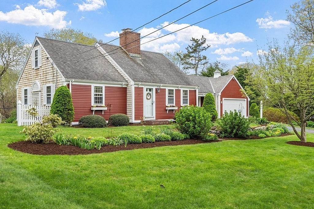 a front view of a house with a garden and plants