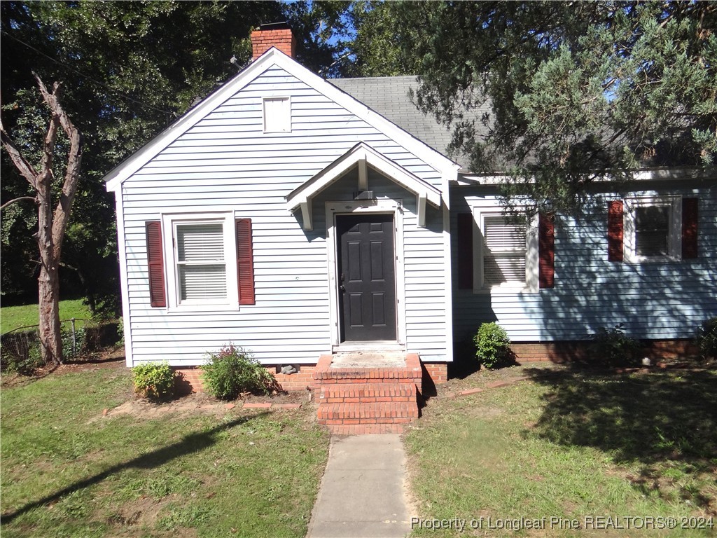 a view of house with backyard and trees