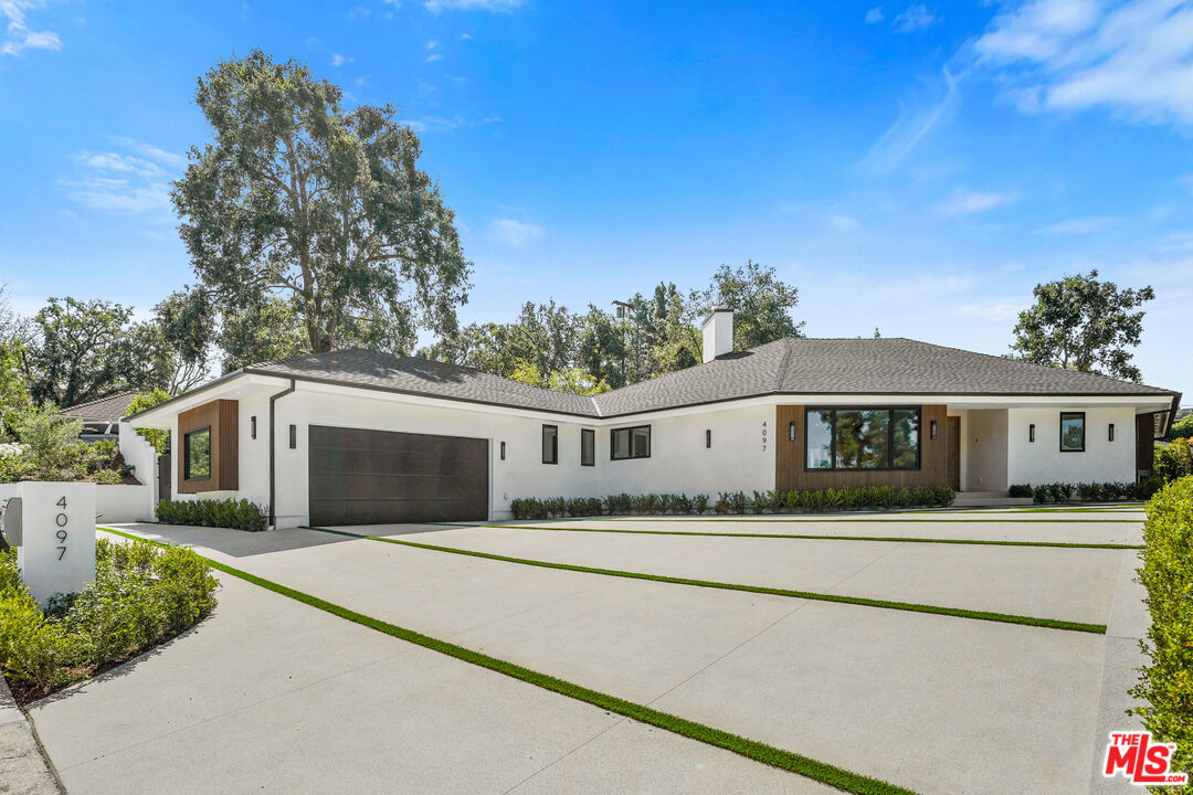 a front view of house with yard and trees in the background