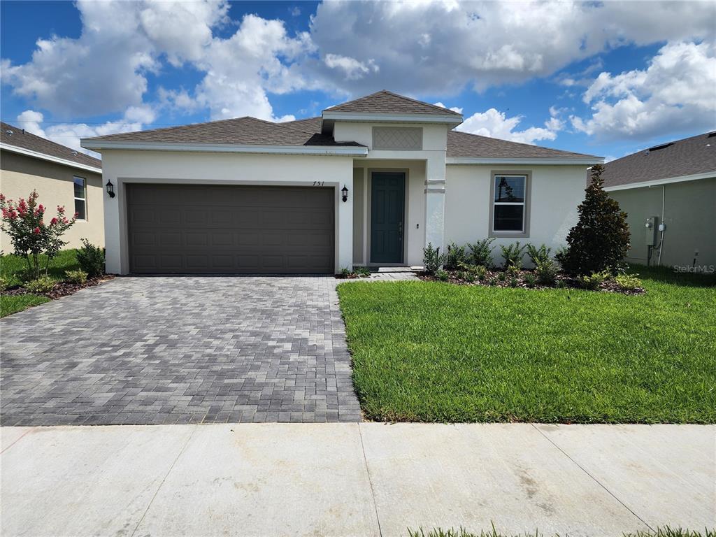 a front view of a house with a yard and garage