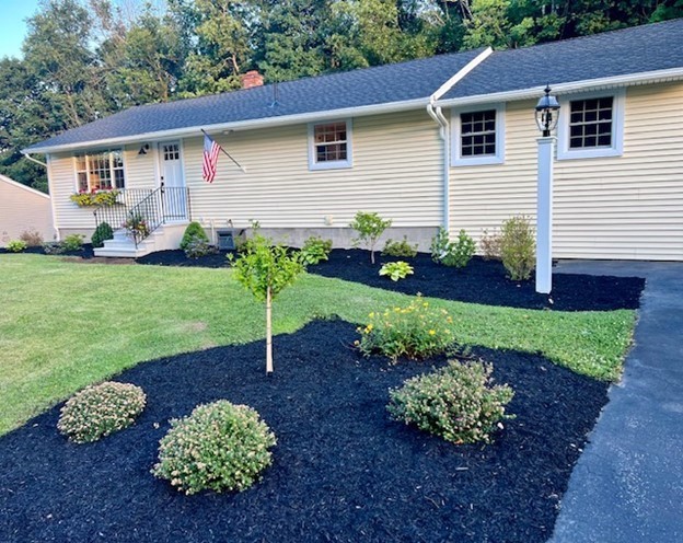 a white house with a yard and garden