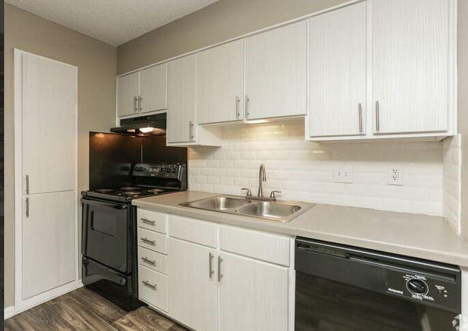 a kitchen with appliances a sink and cabinets