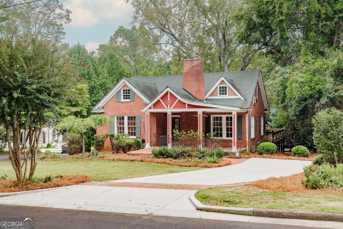 a front view of a house with a yard and potted plants