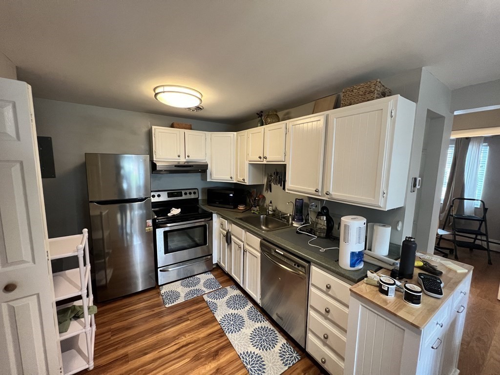 a kitchen with granite countertop a refrigerator stove and microwave