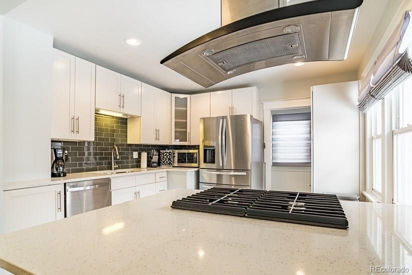 a kitchen with stainless steel appliances a refrigerator a sink a stove and cabinets