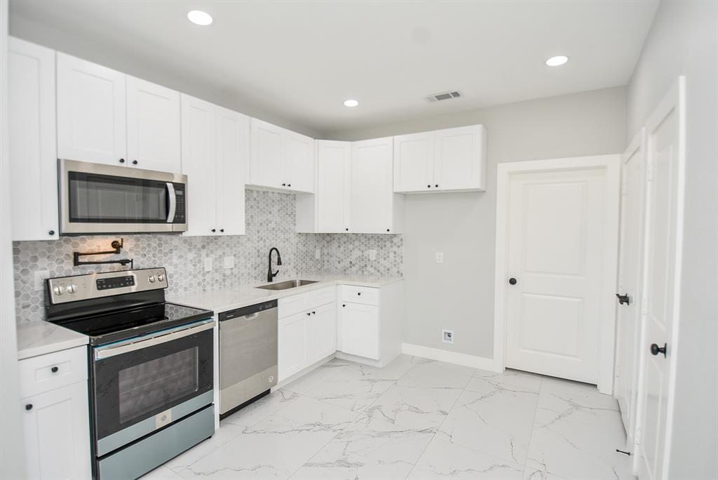 a kitchen with a sink stove and microwave