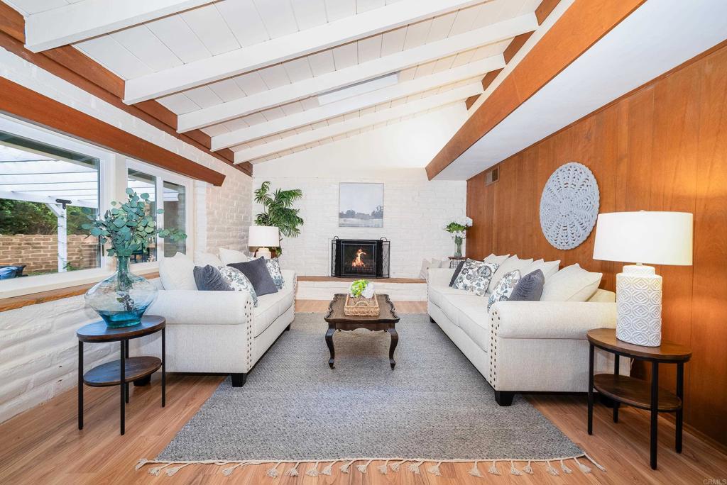 a living room with fireplace furniture and a large window