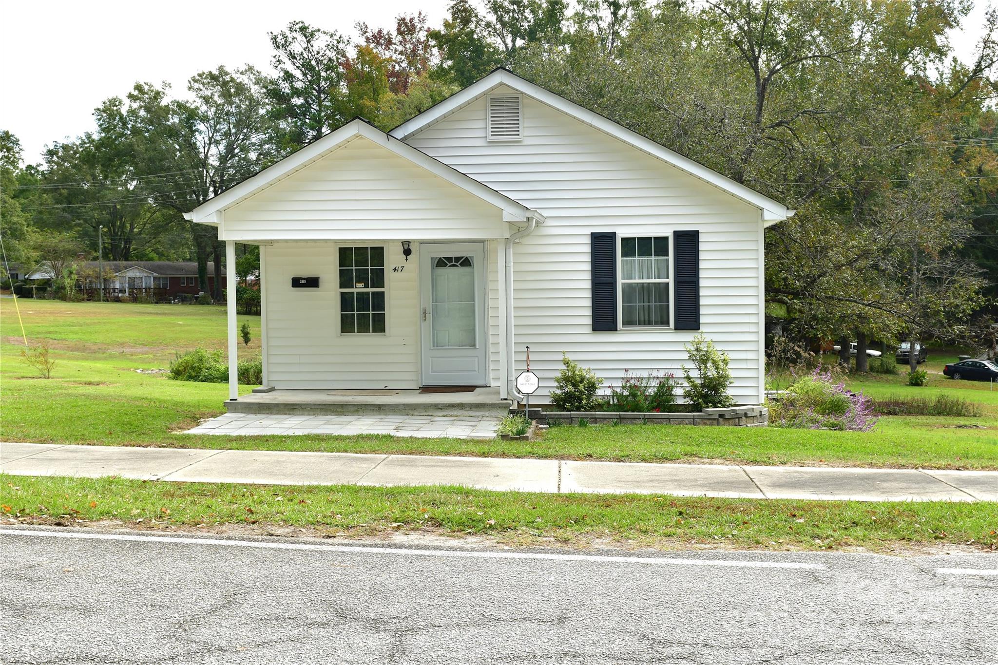 a view of a house with a yard and fence