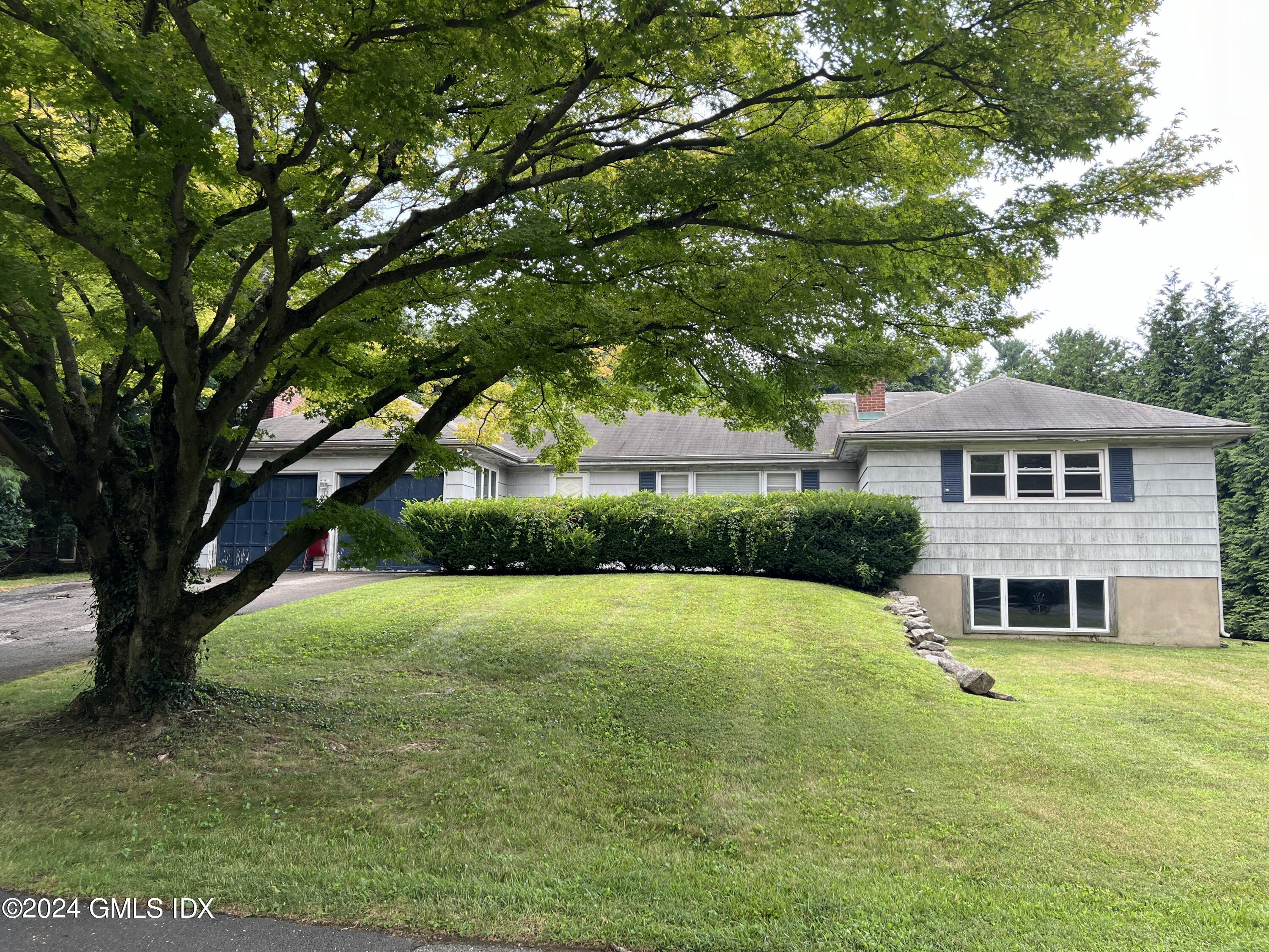 a front view of a house with yard and green space