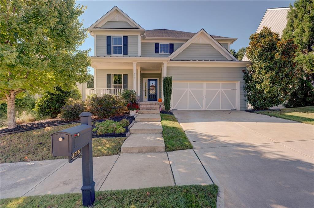 a front view of a house with a yard and a garden