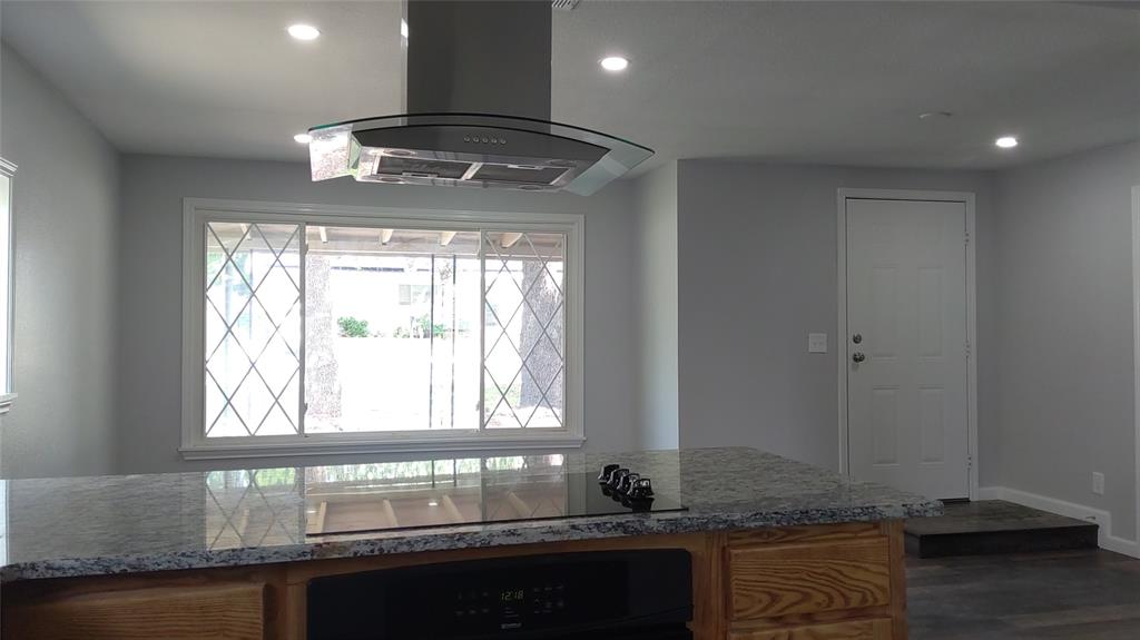 a kitchen with granite countertop a stove and a white counter top