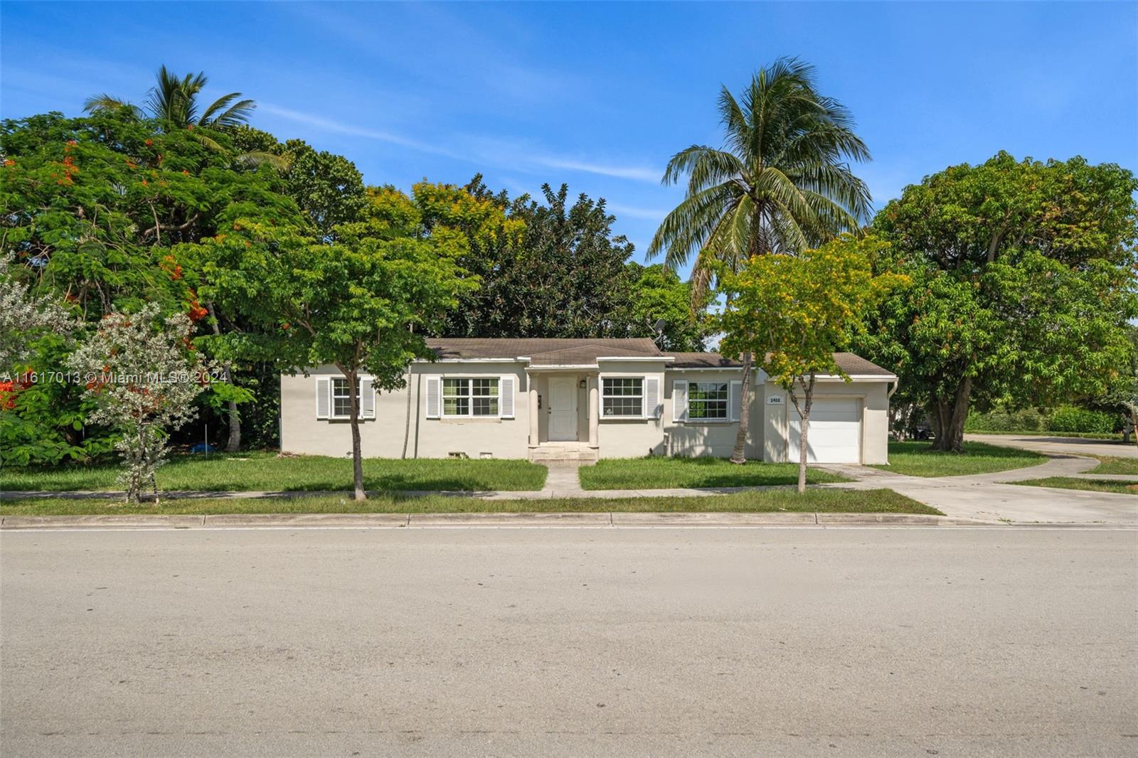 a front view of a house with a yard and trees