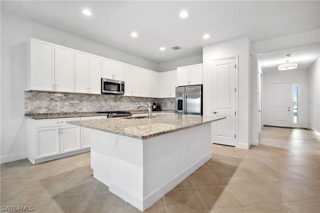 a kitchen with stainless steel appliances granite countertop a stove a sink and a refrigerator