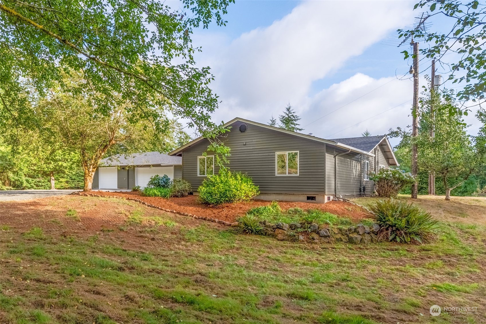 a front view of house with yard and trees around