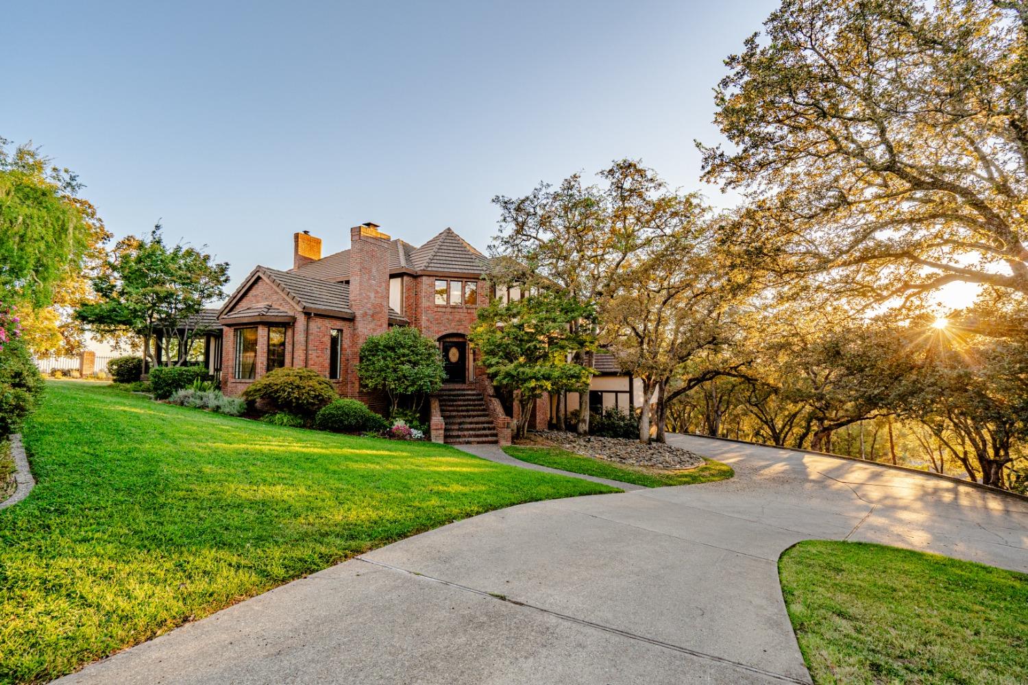 a front view of a house with a yard and trees