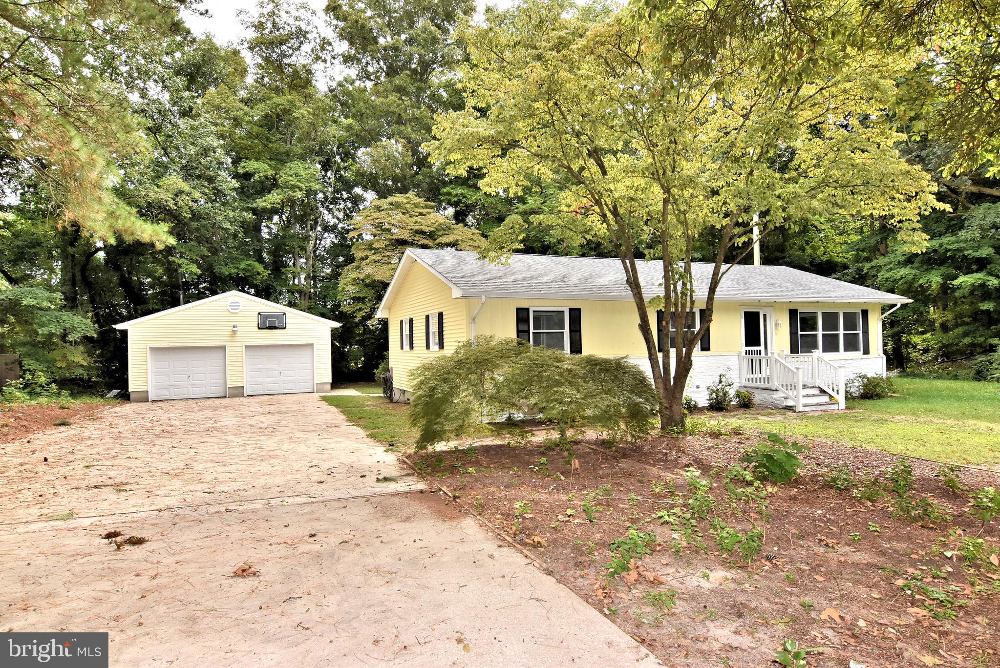 a front view of a house with a yard and trees