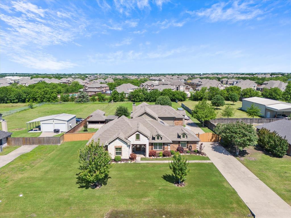 an aerial view of residential houses with outdoor space and trees