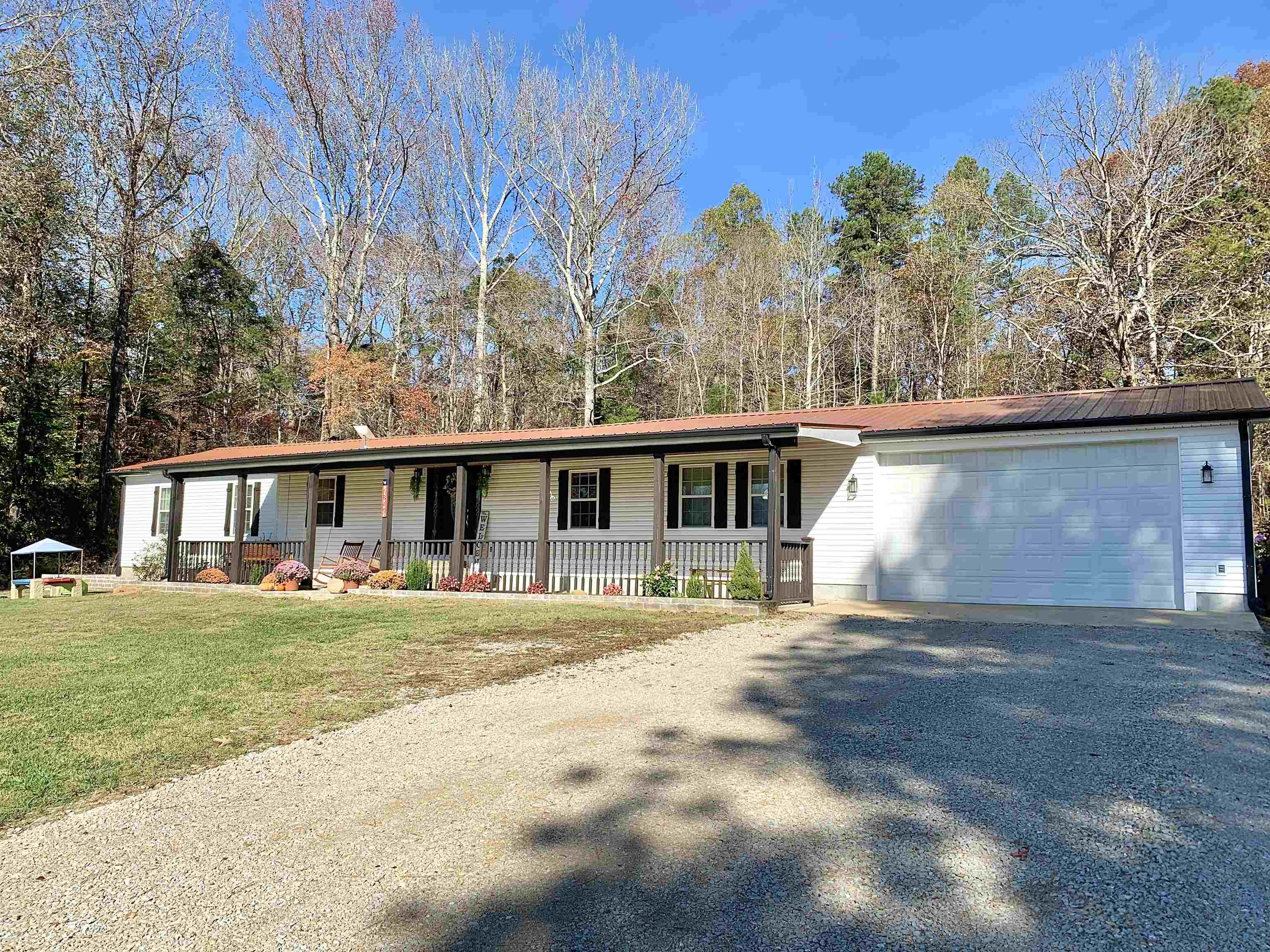 View of front of property featuring a front yard, a porch, and a garage