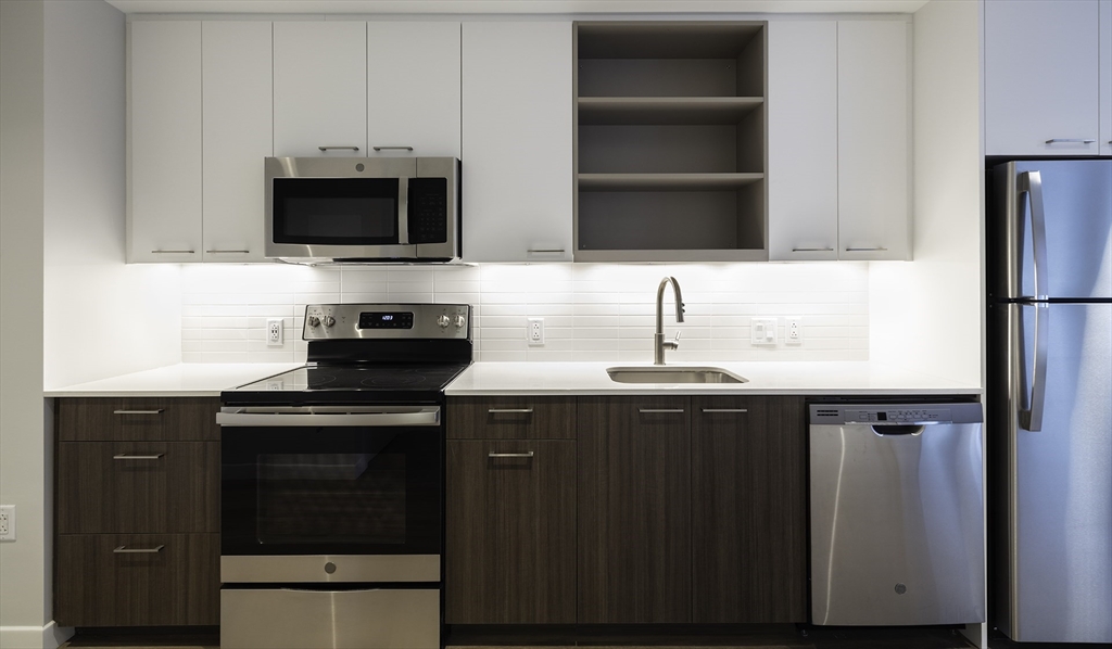 a kitchen with stainless steel appliances wooden cabinets and a sink