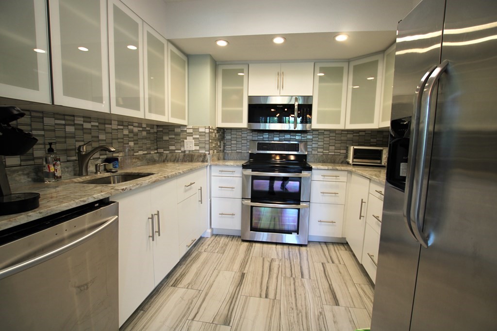 a kitchen with stainless steel appliances a refrigerator sink and microwave