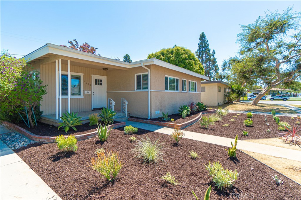 a front view of a house with a yard and potted plants