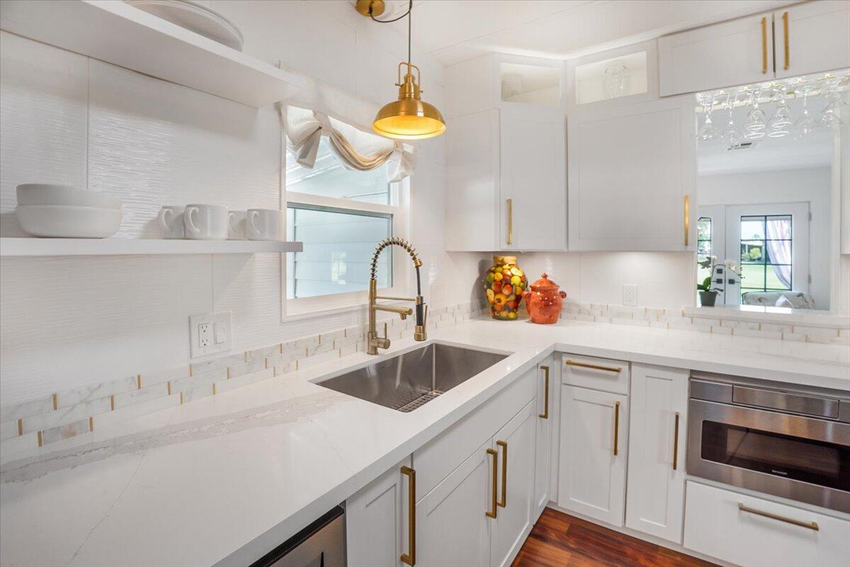 a kitchen with a sink and a stove with wooden floors