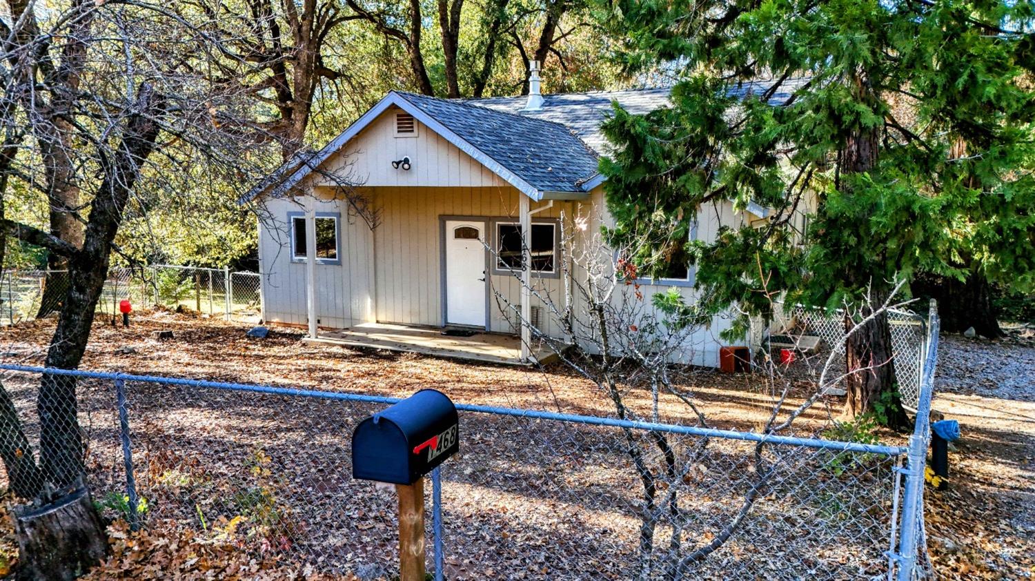 a front view of house with yard and trees in the background