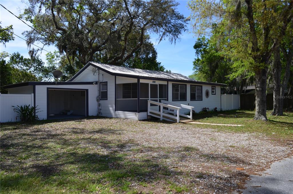 a view of a house with backyard and trees