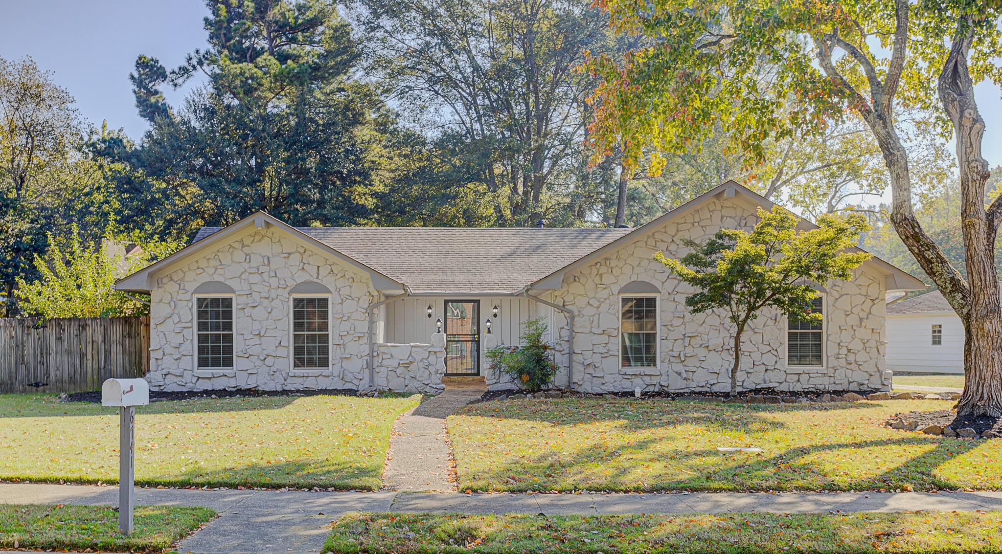 a front view of house with yard and trees around