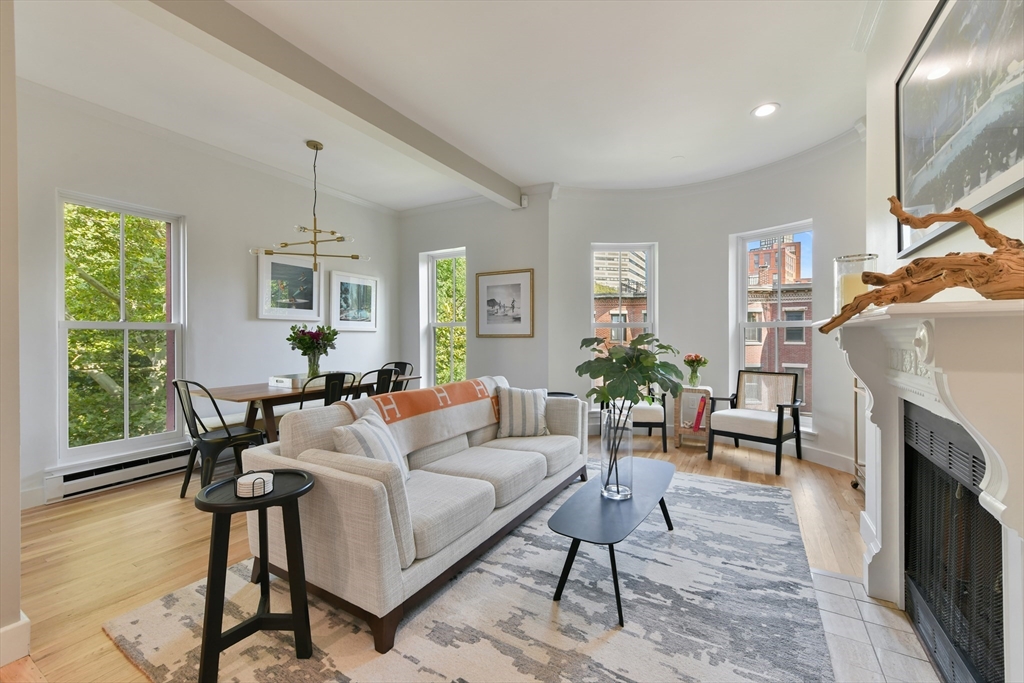 a living room with furniture a fireplace and a large window