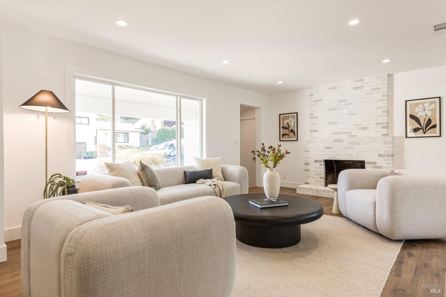 a living room with furniture fireplace and a large window