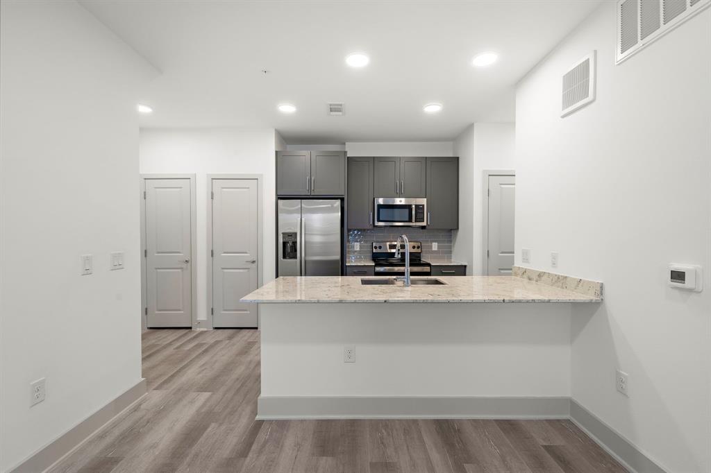 a view of kitchen with stainless steel appliances a sink and a refrigerator