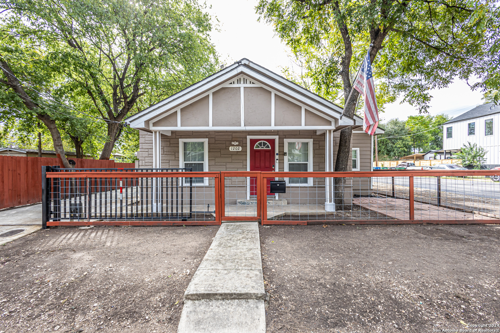 a view of a house with a yard and fence