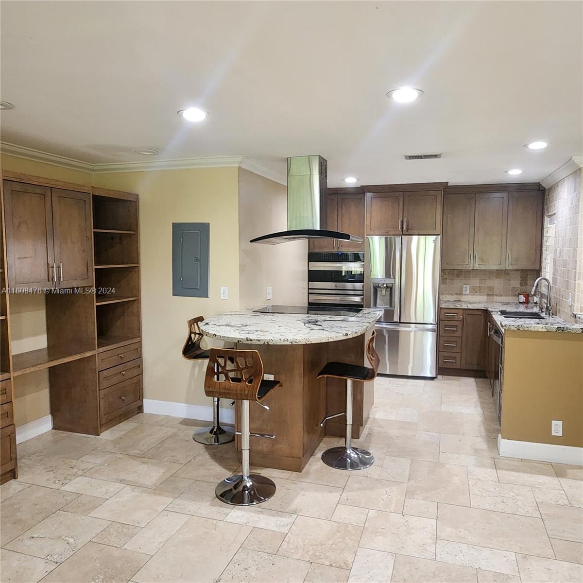 a kitchen with stainless steel appliances kitchen island granite countertop a refrigerator and a stove top oven