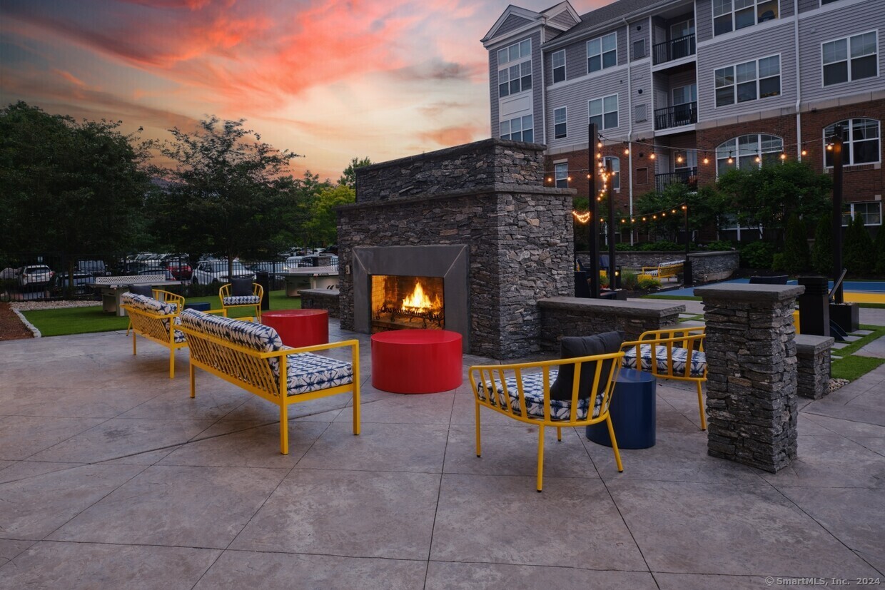 a view of a chairs and table in the patio in front of a building