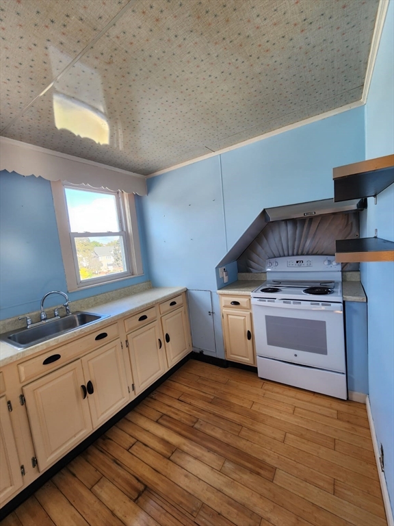 a kitchen with granite countertop a stove and a wooden floors