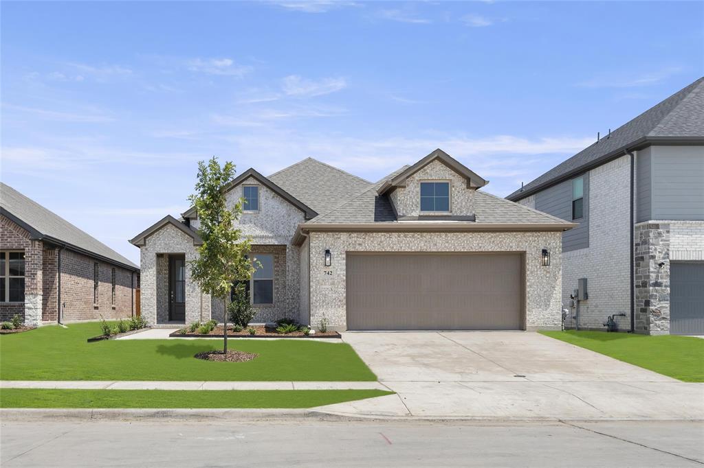 a front view of a house with a yard and garage