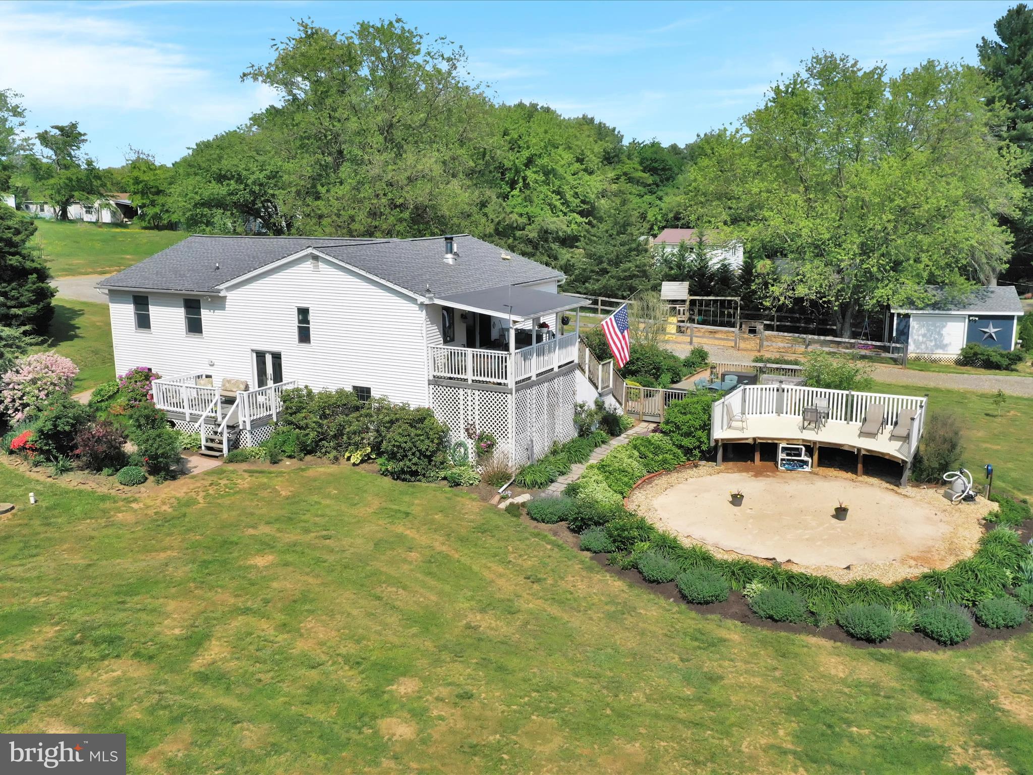 an aerial view of a house with swimming pool and trees in the background