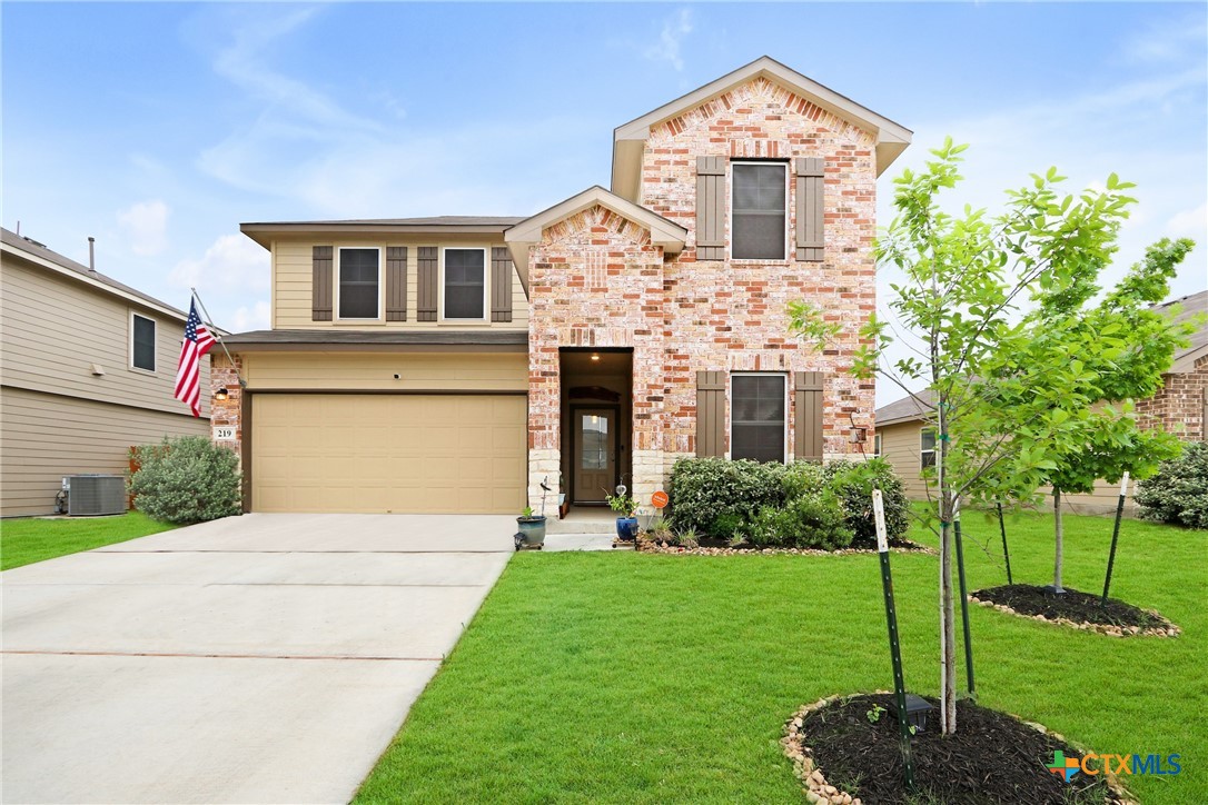 a front view of a house with a yard and garage