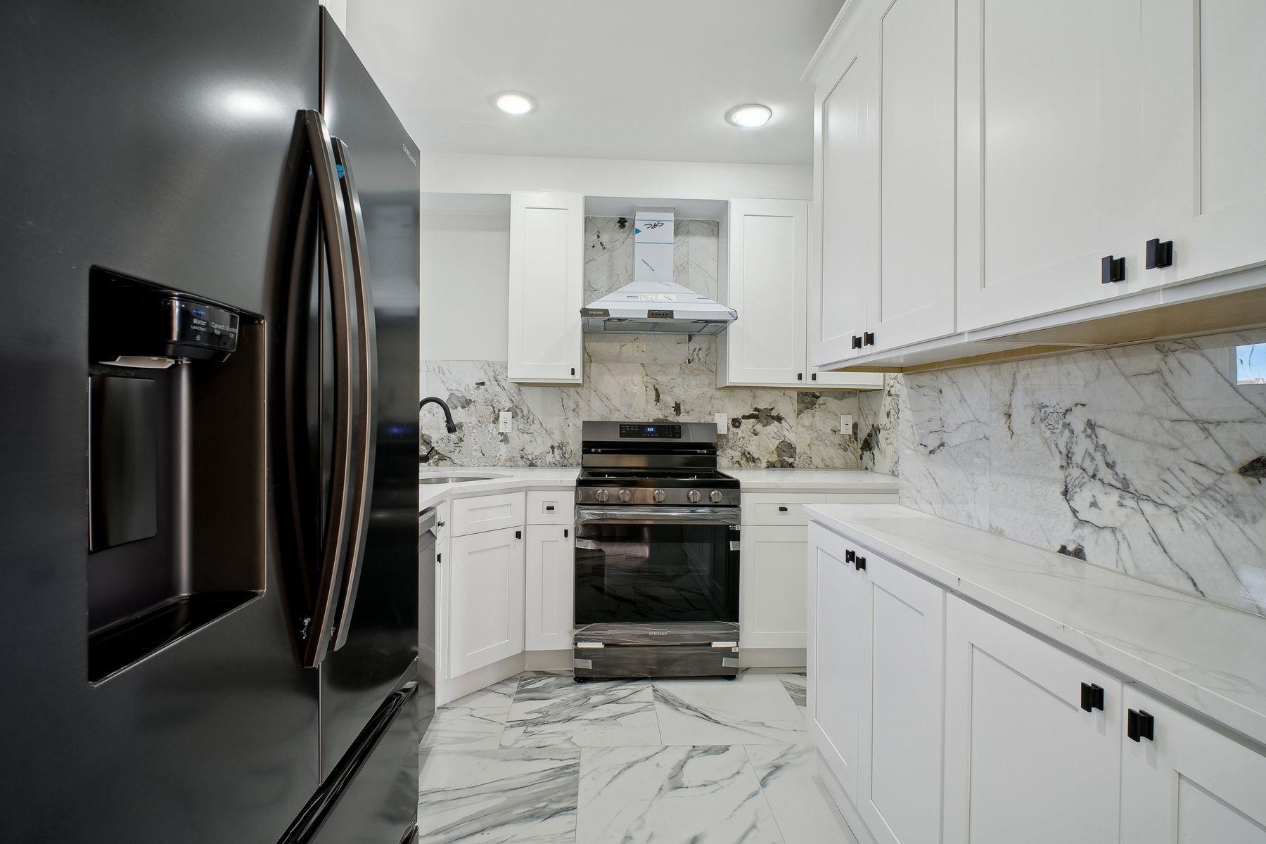 a kitchen with stainless steel appliances granite countertop a refrigerator and a stove